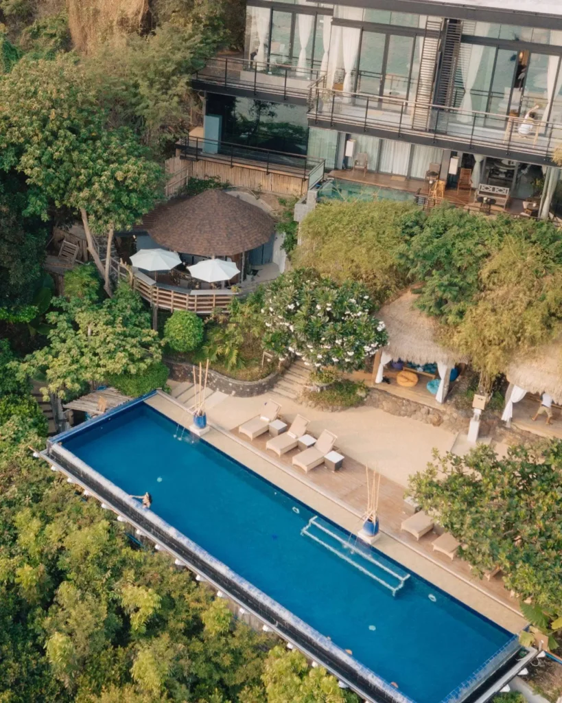 aerial view with pool, hotel and trees