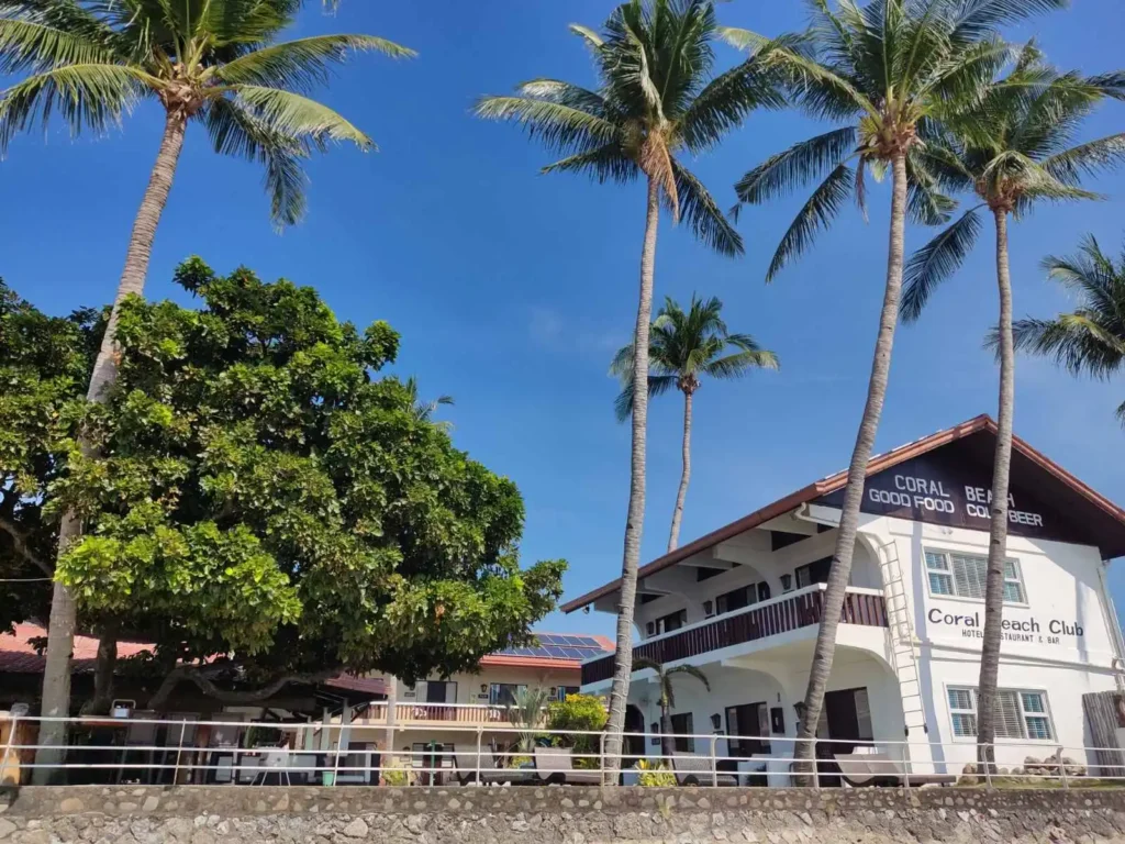 white hotel, sand and trees