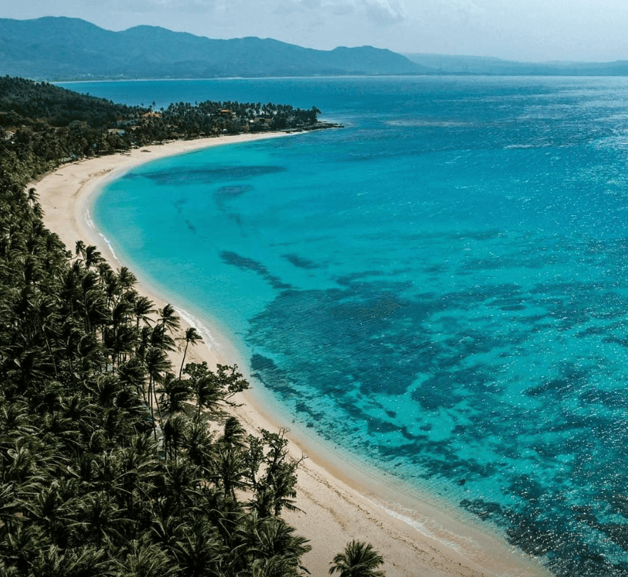 aerial view of a beach with blue water